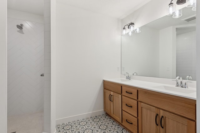 bathroom with a tile shower, tile floors, and double sink vanity