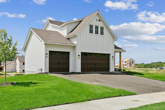 modern inspired farmhouse featuring a front yard and a garage