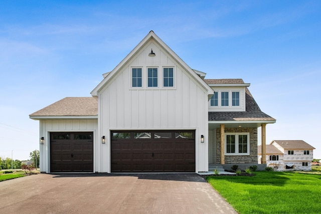 modern farmhouse style home featuring a front lawn and a garage