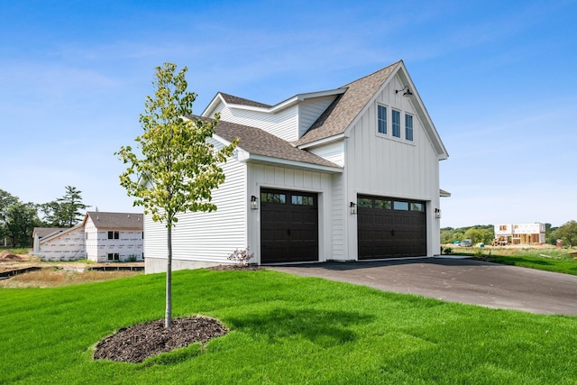 modern inspired farmhouse featuring a front lawn and a garage