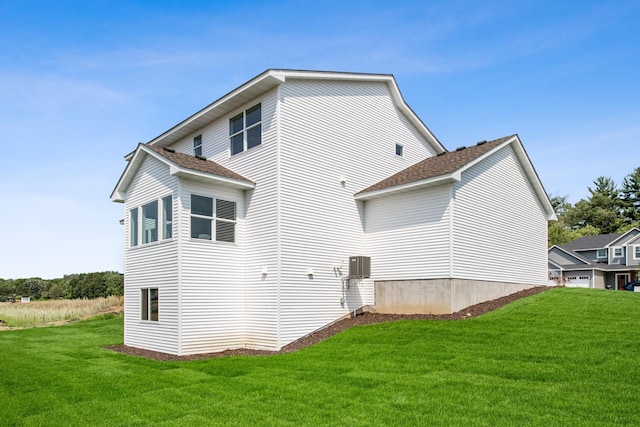 rear view of property featuring a lawn and a garage