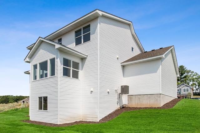 back of house with a lawn and central AC