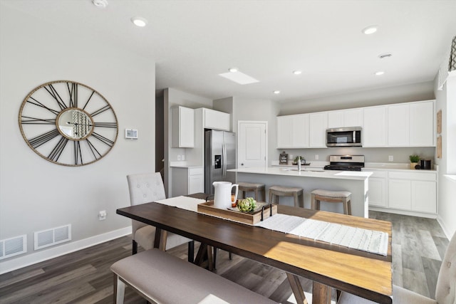 dining room with dark hardwood / wood-style flooring and sink