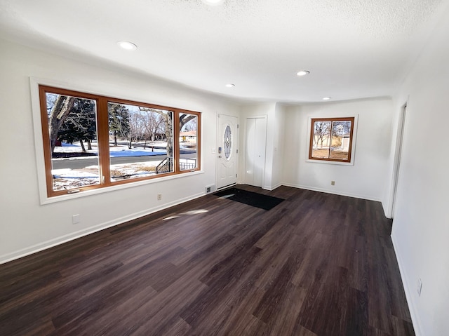 spare room with plenty of natural light and dark hardwood / wood-style flooring