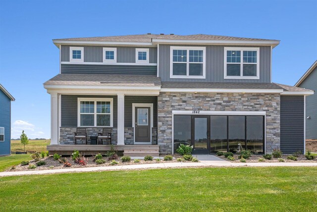 view of front of home with covered porch and a front lawn