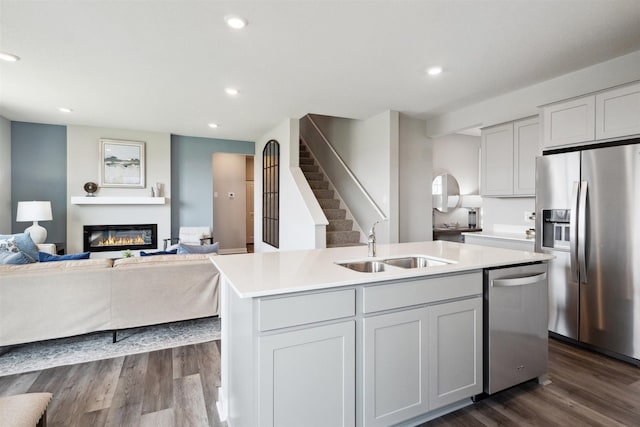 kitchen featuring appliances with stainless steel finishes, sink, an island with sink, and white cabinets