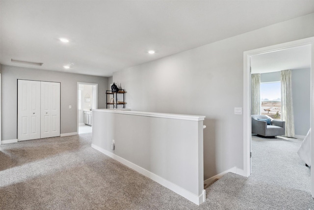 hall featuring light colored carpet