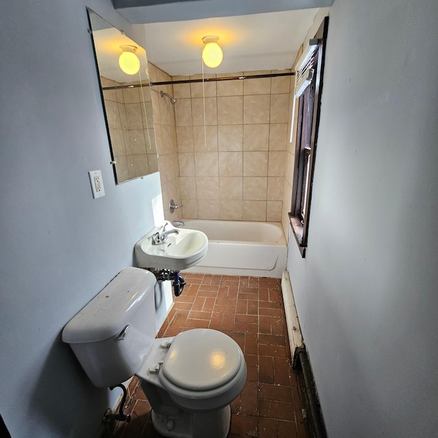 full bathroom featuring toilet, tiled shower / bath combo, and sink