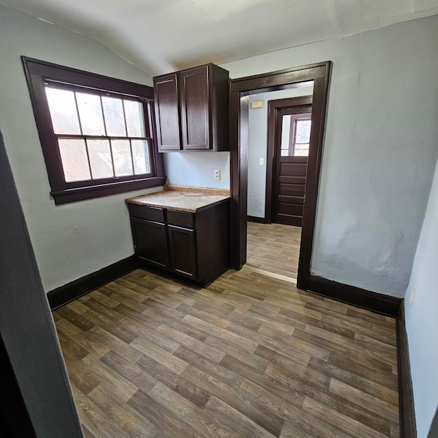 kitchen featuring dark hardwood / wood-style floors, dark brown cabinetry, and vaulted ceiling