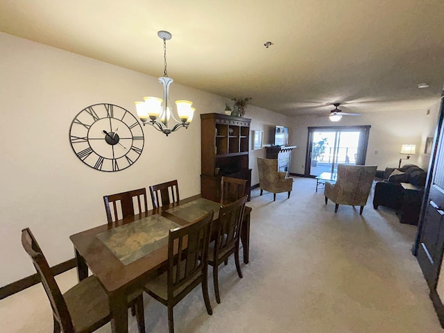 dining room with carpet flooring and ceiling fan with notable chandelier