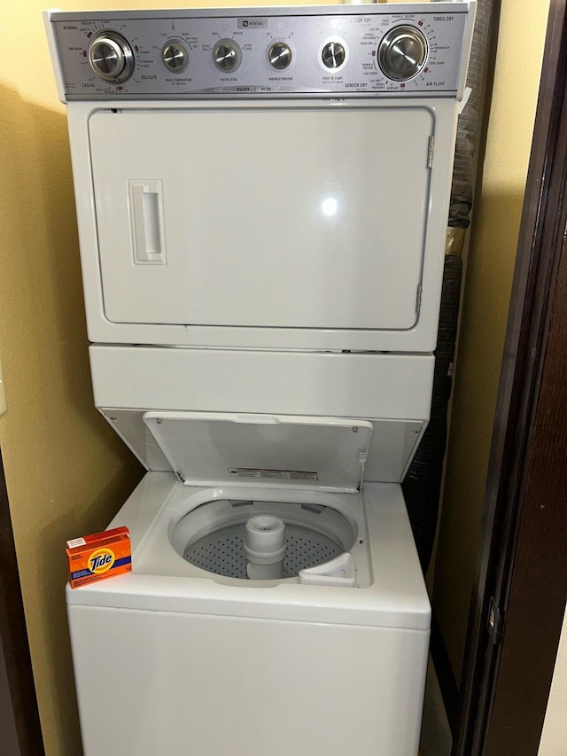 clothes washing area featuring stacked washer and dryer