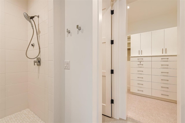 bathroom featuring tile flooring and a tile shower