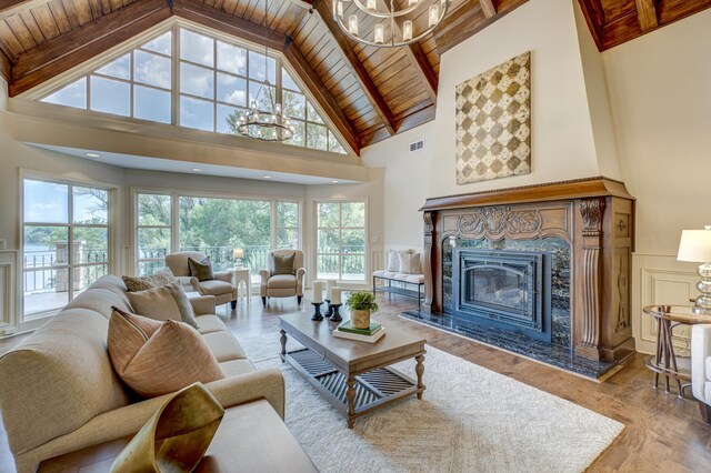 living room with wood ceiling, a premium fireplace, high vaulted ceiling, and beam ceiling