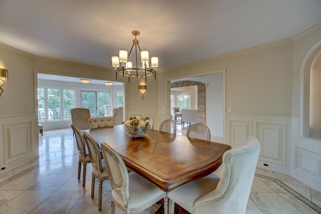 tiled dining area featuring an inviting chandelier and crown molding