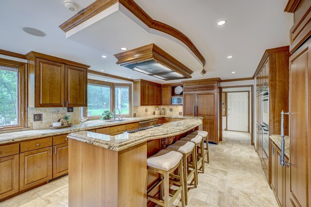 kitchen featuring a center island, light tile patterned flooring, light stone countertops, and tasteful backsplash