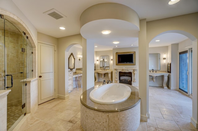 bathroom with vanity, a premium fireplace, shower with separate bathtub, and tile patterned flooring