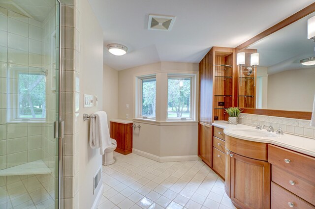 bathroom with a shower with shower door, tile patterned flooring, toilet, and vanity