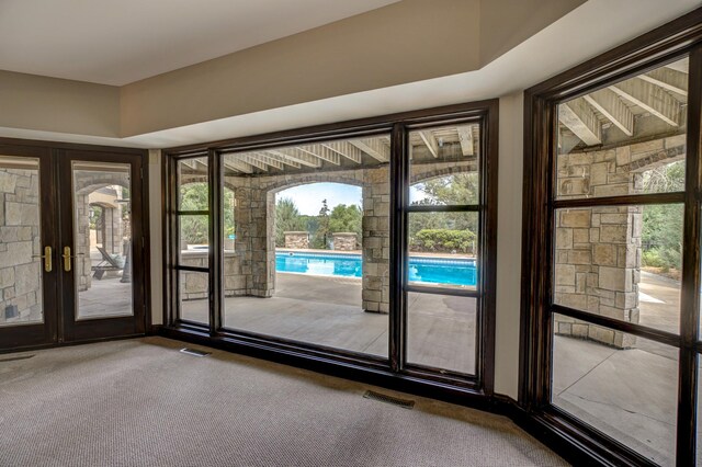 doorway to outside featuring french doors, a wealth of natural light, and carpet