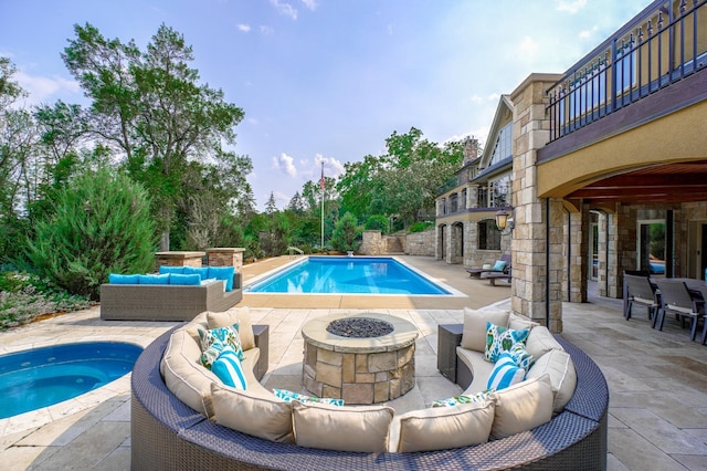 view of swimming pool with an outdoor living space with a fire pit and a patio