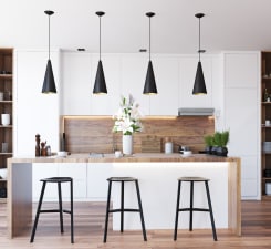 kitchen with a breakfast bar, pendant lighting, white cabinetry, and light wood-type flooring