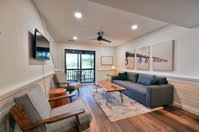 living room featuring ceiling fan and dark wood-type flooring