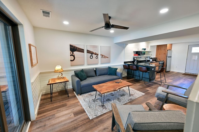 living room with hardwood / wood-style flooring, ceiling fan, and sink