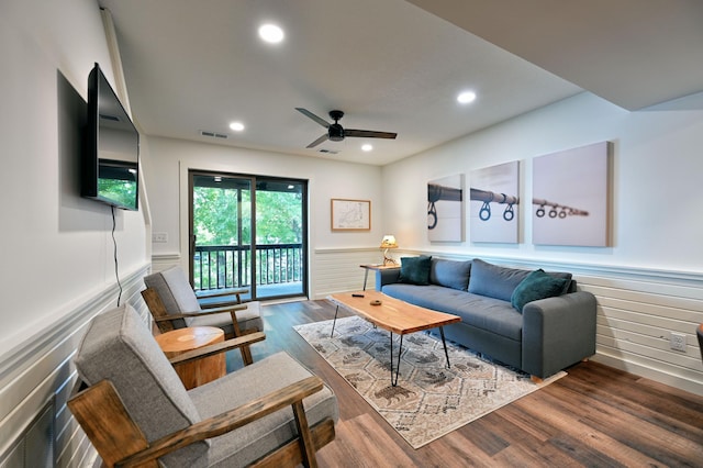 living room featuring ceiling fan and dark hardwood / wood-style flooring