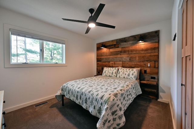 bedroom with ceiling fan and dark carpet