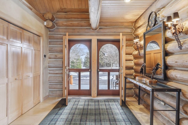 entrance foyer with light tile patterned flooring, a healthy amount of sunlight, rustic walls, and wood ceiling