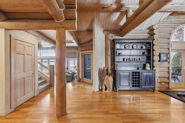 bar featuring light wood-type flooring, wooden ceiling, and beam ceiling