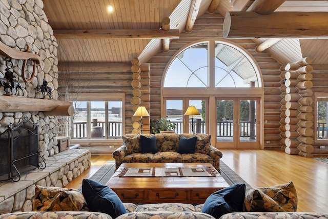 living room featuring a fireplace, light hardwood / wood-style flooring, wood ceiling, and high vaulted ceiling