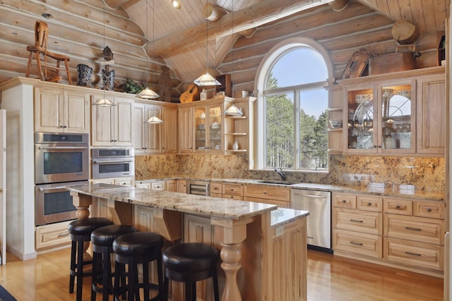 kitchen featuring vaulted ceiling with beams, stainless steel appliances, light stone counters, pendant lighting, and a kitchen island