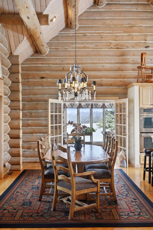 dining area with beam ceiling, high vaulted ceiling, wood-type flooring, and wooden ceiling