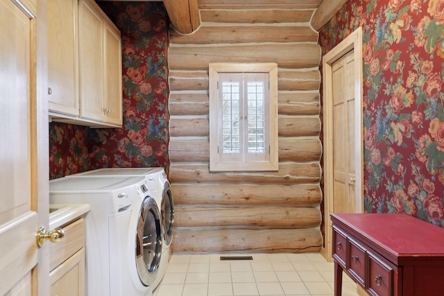 clothes washing area with cabinets, washing machine and dryer, and log walls