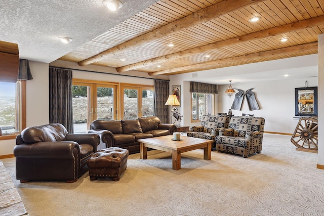 living room with beam ceiling, plenty of natural light, light colored carpet, and wooden ceiling