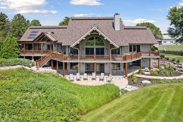 rear view of property featuring a patio, a yard, and a wooden deck