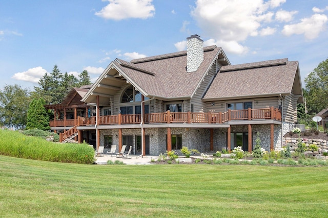 back of house with a wooden deck, a patio, and a lawn