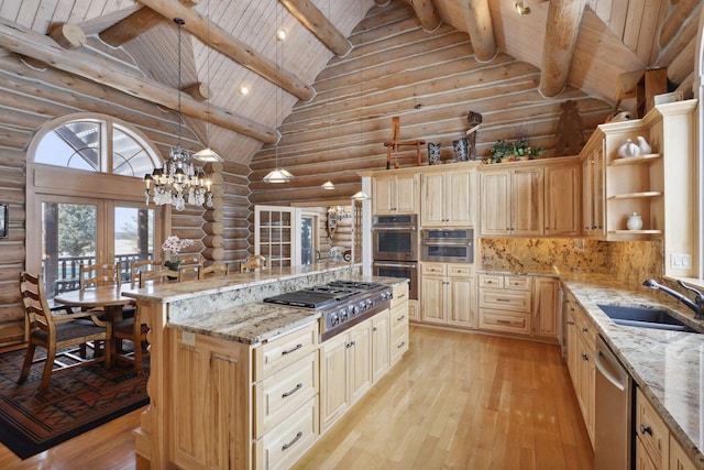 kitchen featuring stainless steel appliances, sink, light stone countertops, and decorative light fixtures