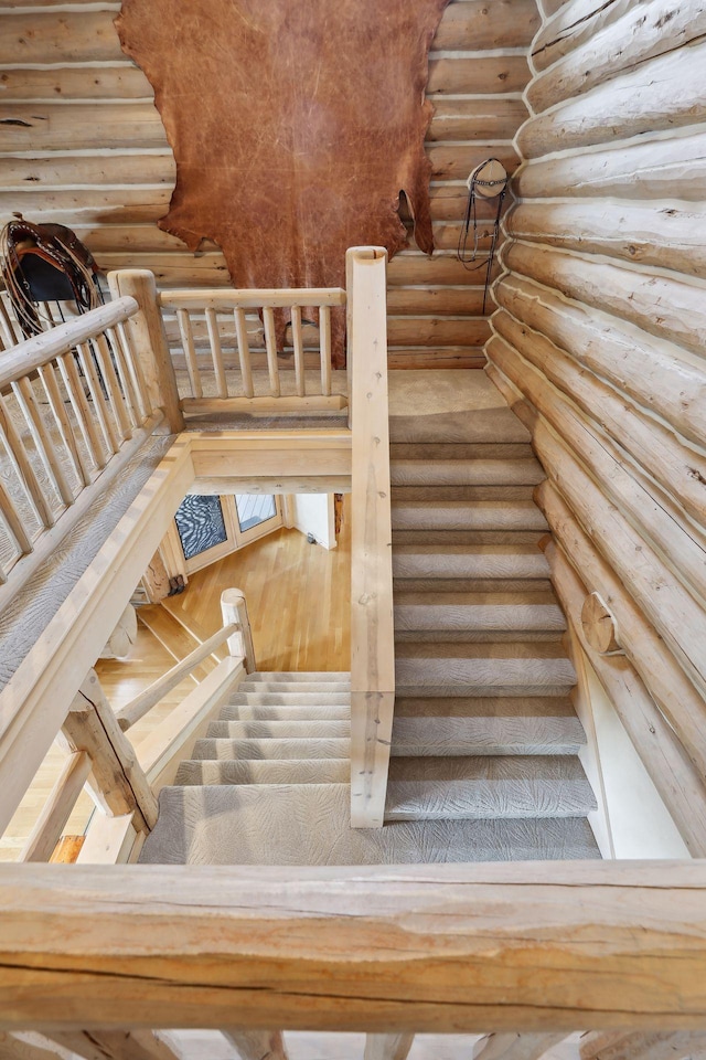 stairs with rustic walls and wood-type flooring