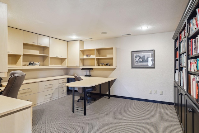 home office featuring carpet and built in desk