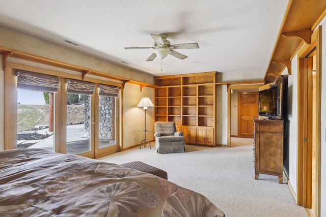 carpeted bedroom featuring french doors, access to exterior, and a textured ceiling