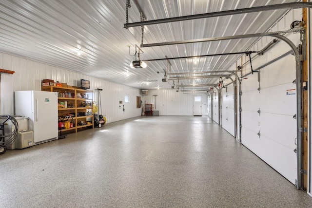 garage with a garage door opener and white refrigerator