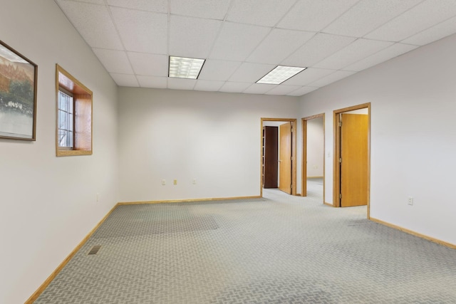 spare room featuring carpet floors and a drop ceiling