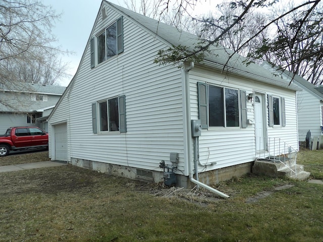 view of side of property with a yard and a garage