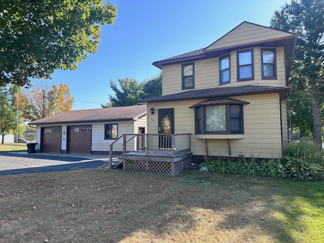 view of front of property with a garage, a wooden deck, and a front yard