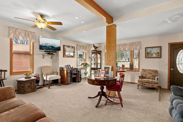 carpeted living room with ceiling fan and beam ceiling