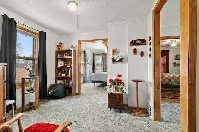 interior space featuring a textured ceiling, ceiling fan, and light carpet