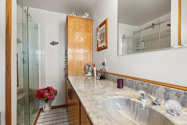 bathroom featuring tile patterned floors, a shower with shower door, and vanity