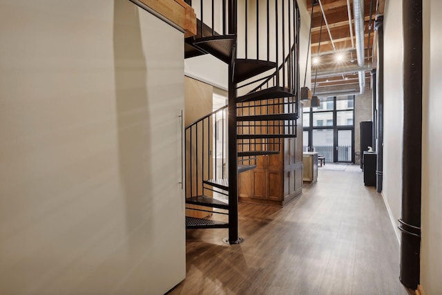 staircase with dark hardwood / wood-style floors and a wall of windows