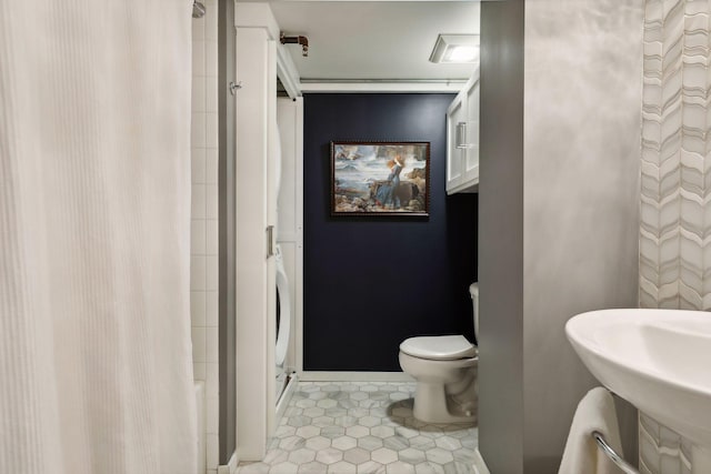 bathroom featuring tile flooring and toilet